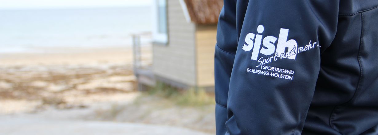 Fotoausschnitt vom Ärmel der blauen Dienstjacke mit weißem Sportjugend-Logo sjsh