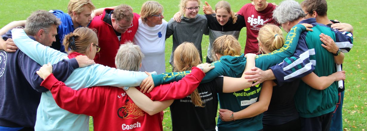 Foto von Jugendgruppe im Kreis, Arm im Arm